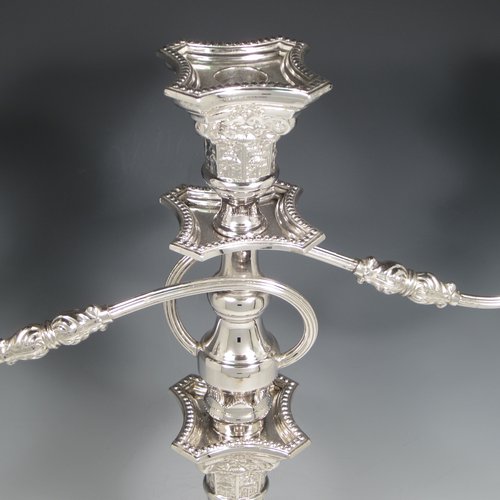 A Sterling silver pair of candelabra in the Corinthian style, having removable arms with three lights, fluted columns with stepped square bases, double swirl reeded arms, acanthus leaf capitals, removable nozzles with drip pans, and bead-edged borders. Made in London in 1933. The dimensions of this fine hand-made silver pair of candelabra are height 49 cms (19.25 inches), and spread across arms 40 cms (15.75 inches).   