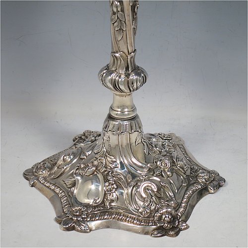 Antique Georgian sterling silver pair of cast Rococo style three-light candelabra, having hand-chased floral decoration with roses and anthemion leaves, removable arms, unusual leaf drip pans, and removable nozzles. Made by William Cafe of London in 1768. Height 45 cms (17.75 inches), spread across arms 39.5 cms (15.5 inches). Total weight approx. 3,705g (119.5 troy ounces).