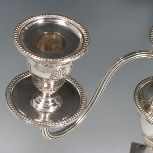    Antique Victorian sterling silver and silver-plated pair of four-light candelabra, having square bases and collumns with neoclassical style chased work, removable arms with drip pans, nozzles, and extinguishers, all with beaded borders. Please note that the bases are sterling silver and the arms are silver-plate. Made by J.K. Bembridge of Sheffield in 1884. Height 47 cms (18.5 inches), spread across arms 27 cms (10.5 inches).