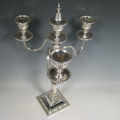    Antique Victorian sterling silver and silver-plated pair of four-light candelabra, having square bases and collumns with neoclassical style chased work, removable arms with drip pans, nozzles, and extinguishers, all with beaded borders. Please note that the bases are sterling silver and the arms are silver-plate. Made by J.K. Bembridge of Sheffield in 1884. Height 47 cms (18.5 inches), spread across arms 27 cms (10.5 inches).