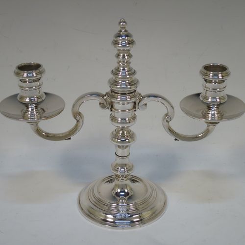 A handsome Sterling silver pair of George I style three-light candelabra, having plain round baluster bodies, fixed arms with drip pans, and central finial that can be pulled out to uncover the third candle holder. Made by Robert Comyns of London in 1937. The dimensions of this fine hand-made pair of silver candelabra are height 20 cms (8 inches), spread across arms 23 cms (9 inches), and with a total weight of approx. 809g (26 troy ounces). Please note that these candelabra are not filled.

   