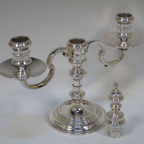 A handsome Sterling silver pair of George I style three-light candelabra, having plain round baluster bodies, fixed arms with drip pans, and central finial that can be pulled out to uncover the third candle holder. Made by Robert Comyns of London in 1937. The dimensions of this fine hand-made pair of silver candelabra are height 20 cms (8 inches), spread across arms 23 cms (9 inches), and with a total weight of approx. 809g (26 troy ounces). Please note that these candelabra are not filled.

   