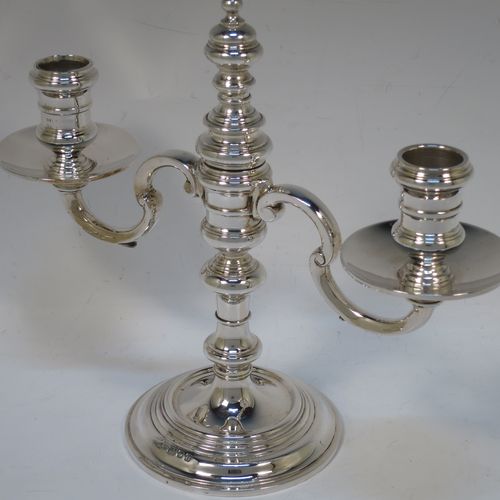 A handsome Sterling silver pair of George I style three-light candelabra, having plain round baluster bodies, fixed arms with drip pans, and central finial that can be pulled out to uncover the third candle holder. Made by Robert Comyns of London in 1937. The dimensions of this fine hand-made pair of silver candelabra are height 20 cms (8 inches), spread across arms 23 cms (9 inches), and with a total weight of approx. 809g (26 troy ounces). Please note that these candelabra are not filled.

   