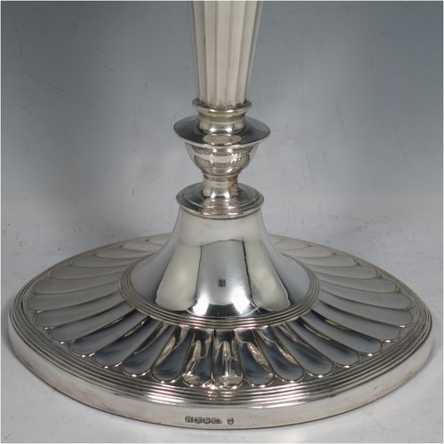 An Antique Victorian Silver Plated pair of candelabra in a Neoclassical style, having removable arms with three lights, fluted columns with oval bases, double swirl and panelled arms, capitals with fluted and reeded decoration, removable nozzles with drip pans, and reed-edged borders. Made by Hawksworth & Eyres in ca. 1900. The dimensions of this fine hand-made pair of silver-plated candelabra are height 37.5 cms (14.75 inches), and spread across arms 32 cms (12.5 inches).   