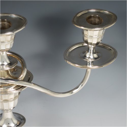 An Antique Victorian Silver Plated pair of candelabra in a Neoclassical style, having removable arms with three lights, fluted columns with oval bases, double swirl and panelled arms, capitals with fluted and reeded decoration, removable nozzles with drip pans, and reed-edged borders. Made by Hawksworth & Eyres in ca. 1900. The dimensions of this fine hand-made pair of silver-plated candelabra are height 37.5 cms (14.75 inches), and spread across arms 32 cms (12.5 inches).   