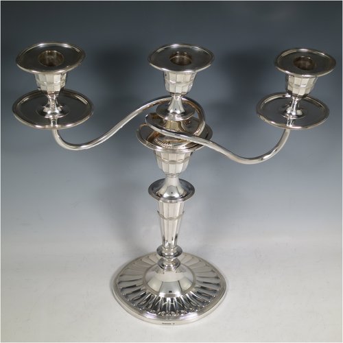 An Antique Victorian Silver Plated pair of candelabra in a Neoclassical style, having removable arms with three lights, fluted columns with oval bases, double swirl and panelled arms, capitals with fluted and reeded decoration, removable nozzles with drip pans, and reed-edged borders. Made by Hawksworth & Eyres in ca. 1900. The dimensions of this fine hand-made pair of silver-plated candelabra are height 37.5 cms (14.75 inches), and spread across arms 32 cms (12.5 inches).   