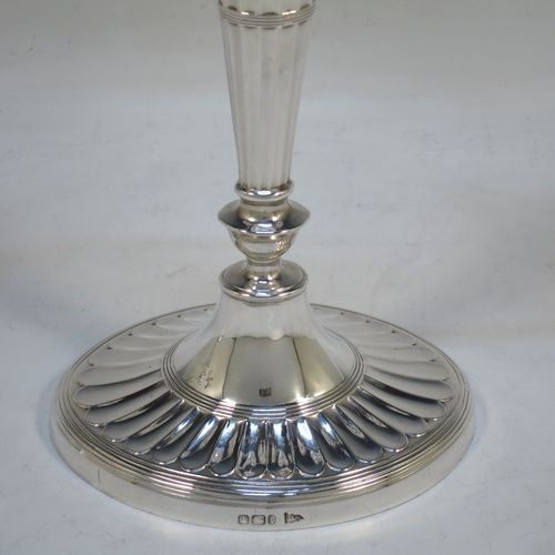 A very pretty pair of Antique Victorian Sterling Silver candelabra in a Neoclassical style with hand-chased fluting and reeded decoration, having removable arms with two lights, with oval bases, reeded scroll-shaped arms, capitals with removable nozzles and drip pans, and reed-edged borders. Made by Walker and Hall of Sheffield in 1901. The dimensions of this fine hand-made pair of antique silver candelabra are height 33 cms (13 inches), and spread across arms 27 cms (10.5 inches).  