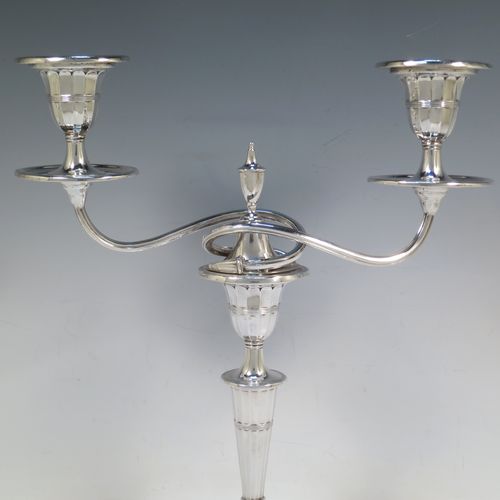 A very pretty pair of Antique Victorian Sterling Silver candelabra in a Neoclassical style with hand-chased fluting and reeded decoration, having removable arms with two lights, with oval bases, reeded scroll-shaped arms, capitals with removable nozzles and drip pans, and reed-edged borders. Made by Walker and Hall of Sheffield in 1901. The dimensions of this fine hand-made pair of antique silver candelabra are height 33 cms (13 inches), and spread across arms 27 cms (10.5 inches).  