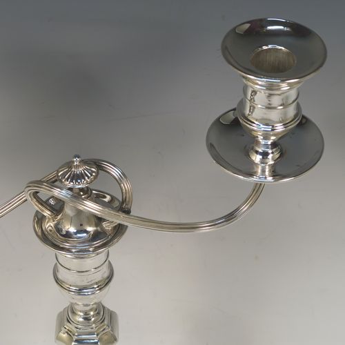 A very handsome pair of Antique Victorian two-light Silver Plated Georgian style candelabra, having cut-corner square bases, panelled baluster columns, with removable swirl and reeded arms, and matching capitals with drip pans and removable nozzles. Made by Elkington and Co., with a date letter for 1896. The dimensions of this fine hand-made pair silver-plated Georgian style  candelabra are height 35 cms (13.75 inches), and spread across arms 25 cms (10 inches).  