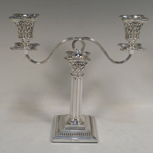 A very pretty pair of Antique Victorian Sterling Silver candelabra in the Corinthian style, having removable arms with two lights, fluted columns with stepped square bases, double swirl reeded arms, acanthus leaf capitals, removable nozzles with drip pans, and bead-edged borders. These beautiful antique silver two-light candelabra were made by Thomas Bradbury and Sons of London in 1879/85. The dimensions of this fine hand-made antique silver pair of candelabra are height 22 cms (8.75 inches), and spread across arms 23 cms (9 inches).   