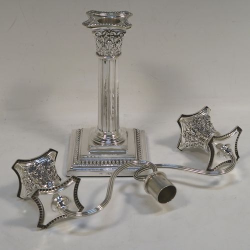 A very pretty pair of Antique Victorian Sterling Silver candelabra in the Corinthian style, having removable arms with two lights, fluted columns with stepped square bases, double swirl reeded arms, acanthus leaf capitals, removable nozzles with drip pans, and bead-edged borders. These beautiful antique silver two-light candelabra were made by Thomas Bradbury and Sons of London in 1879/85. The dimensions of this fine hand-made antique silver pair of candelabra are height 22 cms (8.75 inches), and spread across arms 23 cms (9 inches).   