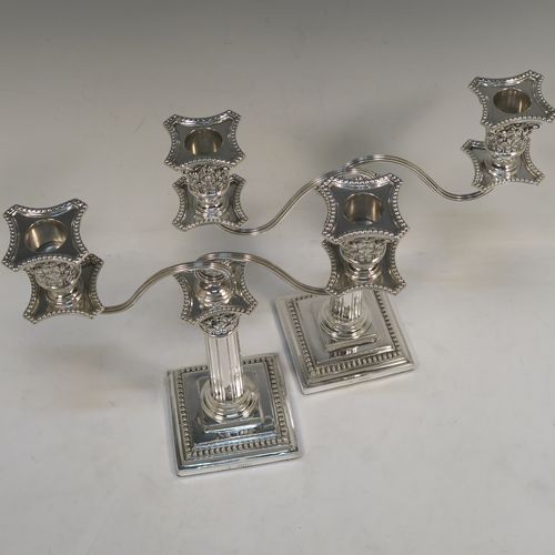 A very pretty pair of Antique Victorian Sterling Silver candelabra in the Corinthian style, having removable arms with two lights, fluted columns with stepped square bases, double swirl reeded arms, acanthus leaf capitals, removable nozzles with drip pans, and bead-edged borders. These beautiful antique silver two-light candelabra were made by Thomas Bradbury and Sons of London in 1879/85. The dimensions of this fine hand-made antique silver pair of candelabra are height 22 cms (8.75 inches), and spread across arms 23 cms (9 inches).   