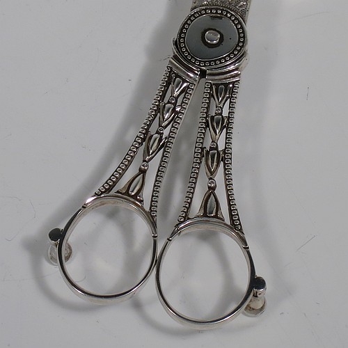 An Antique Georgian Sterling Silver candle scissor snuffer and stand, in a neoclassical style with applied bead-edged borders, and an oval boat-shaped stand. The scissor snuffers made by Walter Brind of London in 1789, and the stand made by John Schofield of London in 1785 (this hallmark has a rare Incuse Duty mark). The dimensions of this fine hand-made antique silver scissor snuffer and stand are length 24 cms (9.5 inches), width 9.5 cms (3.75 inches), and they weigh a total of approx. 213g (6.9 troy ounces).    