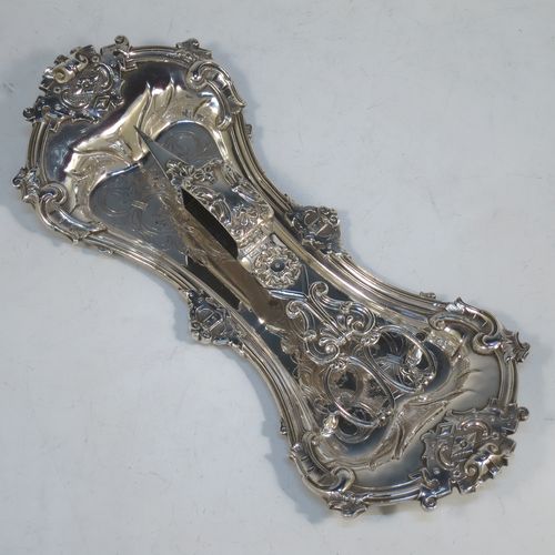 An Antique Georgian Old Sheffield Plated candle scissor snuffer stand and candle scissor snuffer, the stand having an applied floral & scroll border, a hand-chased ground with floral decoration, and sitting on a flat base with four stud feet. The scissor snuffer with matching decoration and all in original working condition. Made in ca. 1830. The dimensions of this fine hand-made antique Old Sheffield Plated snuffer stand and scissors are length 26 cms (10.25 inches), and width 11 cms (4.25 inches),  