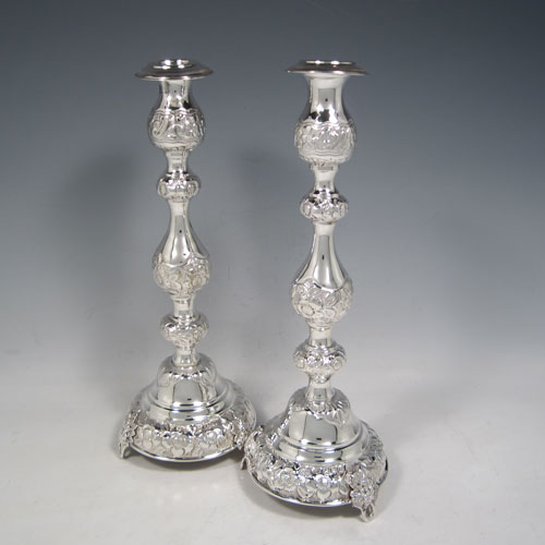 Sterling silver pair of very pretty Sabbath candlesticks, having round baluster bodies with hand-chased floral decoration, with removable nozzles, and sitting on three pierced feet. Made by Jacob Rosenzweig of London in 1917. The dimensions of these fine hand-made silver candlesticks are height 30 cms (11.75 inches), diameter of bases 11 cms (4.25 inches), and they weigh a total of approx. 558g (18 troy ounces). Please note that these candlesticks are not filled.