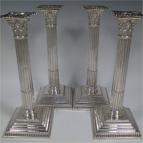 A very handsome set of four Sterling Silver table candlesticks, in a Neoclassical Corinthian style having square stepped bases, fluted columns, acanthus leaf capitals, removable nozzles, and gadroon borders. Made by D and J Welby of London in 1936. The dimensions of this fine hand-made set of four silver candlesticks are height 26 cms (10.25 inches), and their bases are 10 cms (4 inches) square.   