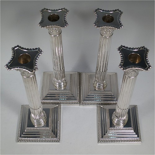 A very handsome set of four Sterling Silver table candlesticks, in a Neoclassical Corinthian style having square stepped bases, fluted columns, acanthus leaf capitals, removable nozzles, and gadroon borders. Made by D and J Welby of London in 1936. The dimensions of this fine hand-made set of four silver candlesticks are height 26 cms (10.25 inches), and their bases are 10 cms (4 inches) square.   