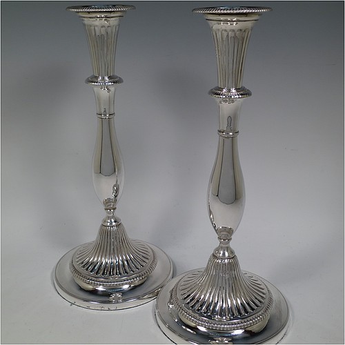 An Antique Georgian Sterling Silver pair of candlesticks, having round bellied bodies with hand-chased fluted decoration, with gadroon borders, and removable nozzles. Made by John Green, Roberts, Mosley and Co., of Sheffield in 1800. The dimensions of these fine hand-made antique silver candlesticks are height 30 cms (11.75 inches), diameter of bases 13.5 cms (5.3 inches) diameter. Please note that these candlesticks are filled.    