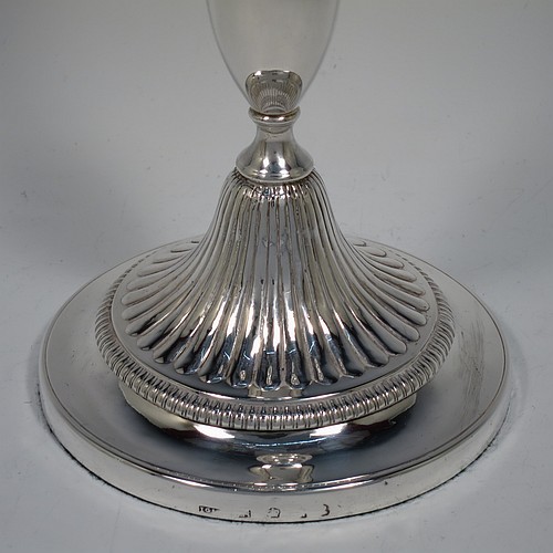 An Antique Georgian Sterling Silver pair of candlesticks, having round bellied bodies with hand-chased fluted decoration, with gadroon borders, and removable nozzles. Made by John Green, Roberts, Mosley and Co., of Sheffield in 1800. The dimensions of these fine hand-made antique silver candlesticks are height 30 cms (11.75 inches), diameter of bases 13.5 cms (5.3 inches) diameter. Please note that these candlesticks are filled.    