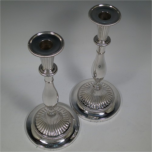 An Antique Georgian Sterling Silver pair of candlesticks, having round bellied bodies with hand-chased fluted decoration, with gadroon borders, and removable nozzles. Made by John Green, Roberts, Mosley and Co., of Sheffield in 1800. The dimensions of these fine hand-made antique silver candlesticks are height 30 cms (11.75 inches), diameter of bases 13.5 cms (5.3 inches) diameter. Please note that these candlesticks are filled.    