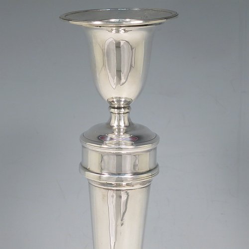 An Antique Georgian Sterling Silver set of four large table candlesticks, in a plain round style, having round bodies with reeded borders, tapering columns, and removable nozzles. Made by John Waterhouse & Co., of Sheffield in 1782. The dimensions of these fine hand-made antique silver candlesticks are height 27.5 cms (10.75 inches), and diameter at bases 14 cms (5.5 inches). Please note that these candlesticks are crested.   