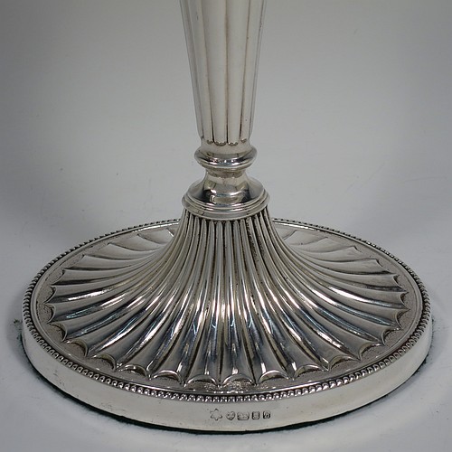 A Sterling Silver very pretty pair of large table candlesticks, in a neoclassical Adams style, having oval bodies with tapering columns and hand-chased inverted flute decoration, with applied bead-edged borders, and removable nozzles. Made by D. J. Silver of London in 1963. The dimensions of these fine hand-made silver candlesticks are height 29 cms (11.5 inches), and length at bases 15 cms (6 inches).