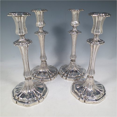 An Antique Georgian Sterling Silver set of four large table candlesticks, having round bodies with hand-chased Melon style fluting, with tapering columns and removable nozzles. Made by Henry Wilkinson of Sheffield in 1835. The dimensions of these fine hand-made antique silver candlesticks are height 28 cms (11 inches), diameter at base 13.5 cms (5.25 inches). Please note that these candlesticks are crested.