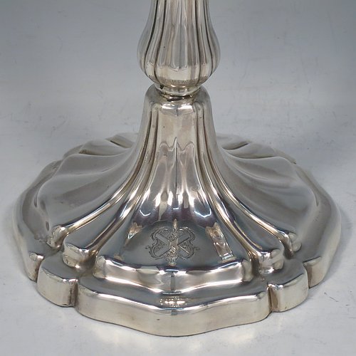 An Antique Georgian Sterling Silver set of four large table candlesticks, having round bodies with hand-chased Melon style fluting, with tapering columns and removable nozzles. Made by Henry Wilkinson of Sheffield in 1835. The dimensions of these fine hand-made antique silver candlesticks are height 28 cms (11 inches), diameter at base 13.5 cms (5.25 inches). Please note that these candlesticks are crested.