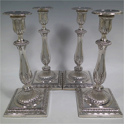 A very pretty set of four Sterling Silver candlesticks in a Neoclassical style, having round baluster bodies with hand-chased anthemion leaf and fluted decoration, with anthemion leaf-edged borders, sitting on square bases with matching decoration, and original removable nozzles. This beautiful set of silver candlesticks were made by Thomas Bradbury of Sheffield in 1921. The dimensions of these fine hand-made silver candlesticks are height 28 cms (11 inches), base 12 cms (4.75 inches) square.    