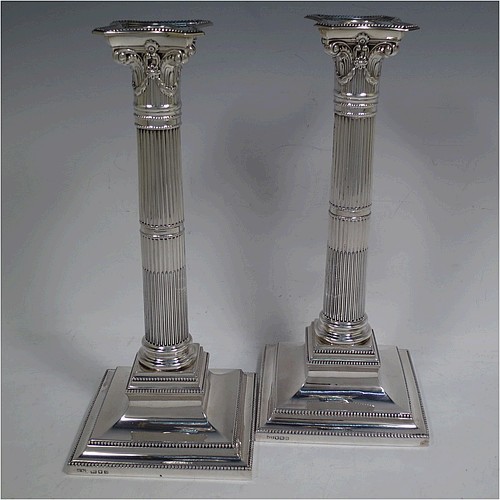 A very pretty pair of Sterling Silver table candlesticks, in a Neoclassical Corinthian style having square stepped bases, fluted columns, swag style capitals, removable nozzles, and bead-edged borders. Made by Mappin and Webb of London in 1935, and Sheffield in 1928. The dimensions of this fine hand-made pair of silver candlesticks are height 26 cms (10.25 inches), and their bases are 11.5 cms (4.5 inches) square.    