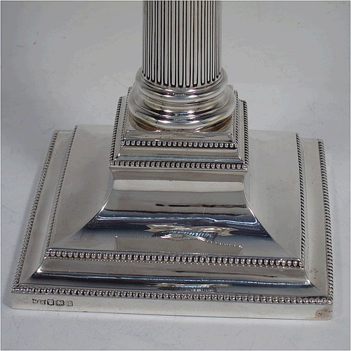 A very pretty pair of Sterling Silver table candlesticks, in a Neoclassical Corinthian style having square stepped bases, fluted columns, swag style capitals, removable nozzles, and bead-edged borders. Made by Mappin and Webb of London in 1935, and Sheffield in 1928. The dimensions of this fine hand-made pair of silver candlesticks are height 26 cms (10.25 inches), and their bases are 11.5 cms (4.5 inches) square.    