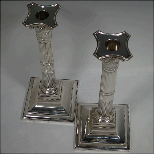 A very pretty pair of Sterling Silver table candlesticks, in a Neoclassical Corinthian style having square stepped bases, fluted columns, swag style capitals, removable nozzles, and bead-edged borders. Made by Mappin and Webb of London in 1935, and Sheffield in 1928. The dimensions of this fine hand-made pair of silver candlesticks are height 26 cms (10.25 inches), and their bases are 11.5 cms (4.5 inches) square.    