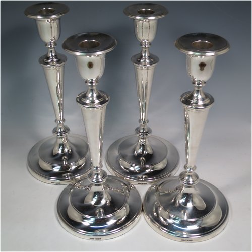 An Antique Victorian Sterling Silver set of four large table candlesticks, in a plain round style, having round bodies with hand-chased reeded borders, tapering columns, and removable nozzles. Made by Elkington & Co., of Sheffield in 1899. The dimensions of these fine hand-made antique silver candlesticks are height 29 cms (11.5 inches), and diameter at bases 14 cms (5.5 inches).   