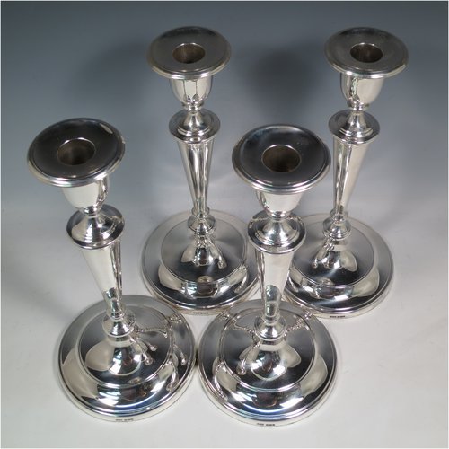 An Antique Victorian Sterling Silver set of four large table candlesticks, in a plain round style, having round bodies with hand-chased reeded borders, tapering columns, and removable nozzles. Made by Elkington & Co., of Sheffield in 1899. The dimensions of these fine hand-made antique silver candlesticks are height 29 cms (11.5 inches), and diameter at bases 14 cms (5.5 inches).   