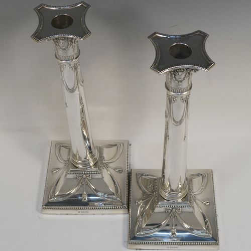 A very pretty pair of Antique Sterling Silver table candlesticks, in a Neoclassical Corinthian style having square bases with hand-chased swags, ribbons and bows, and bead-edged borders, with original removable nozzles. This beautiful pair of antique silver candlesticks were made by Thomas Bradbury and Sons of Sheffield in 1918. The dimensions of this fine hand-made pair antique silver candlesticks are height 31 cms (12.25 inches), and their bases are 12.5 cms (5 inches) square.   