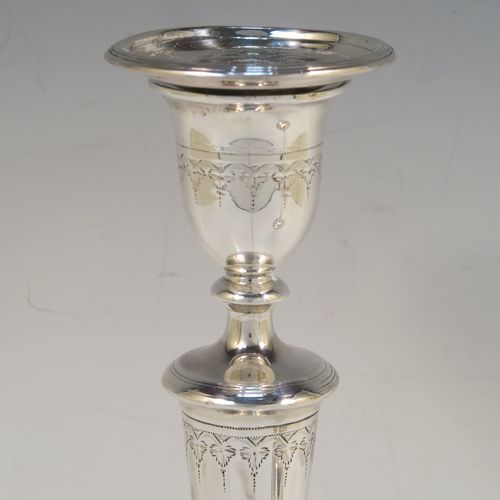 A very elegant pair of Antique Georgian Sterling Silver candlesticks, having round bodies with tapering sides, hand-chased bands of floral decoration, and reeded  borders with original removable nozzles. These handsome antique silver table candlesticks were made by John Parsons and Co., of Sheffield in 1792. The dimensions of these fine hand-made antique Georgian silver candlesticks are height 27 cms (10.5 inches), and diameter of bases are 13 cms (5 inches) diameter.  