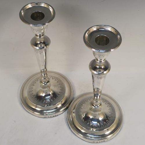 A very elegant pair of Antique Georgian Sterling Silver candlesticks, having round bodies with tapering sides, hand-chased bands of floral decoration, and reeded  borders with original removable nozzles. These handsome antique silver table candlesticks were made by John Parsons and Co., of Sheffield in 1792. The dimensions of these fine hand-made antique Georgian silver candlesticks are height 27 cms (10.5 inches), and diameter of bases are 13 cms (5 inches) diameter.  