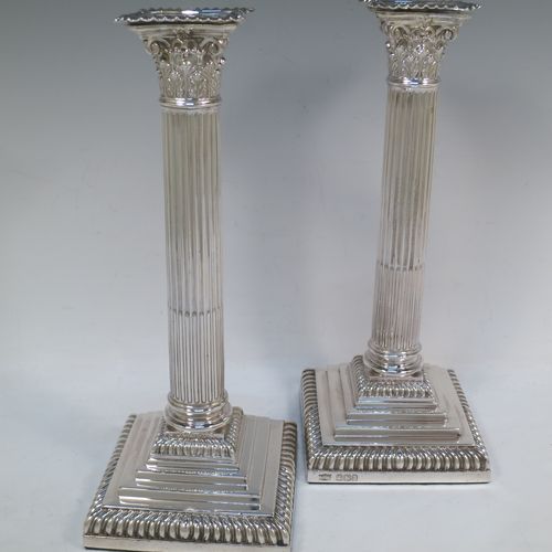 A very handsome pair of Antique Victorian Sterling Silver table candlesticks, in a Neoclassical Corinthian style having square stepped bases, fluted columns, acanthus leaf capitals, removable nozzles, and gadroon borders. Made by Hawksworth, Eyre and Co., of Sheffield in 1893. The dimensions of this fine hand-made pair of antique silver candlesticks are height 28 cms (11 inches), and their bases are 11 cms (4.3 inches) square.  