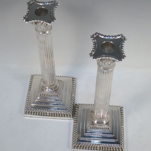 A very handsome pair of Antique Victorian Sterling Silver table candlesticks, in a Neoclassical Corinthian style having square stepped bases, fluted columns, acanthus leaf capitals, removable nozzles, and gadroon borders. Made by Hawksworth, Eyre and Co., of Sheffield in 1893. The dimensions of this fine hand-made pair of antique silver candlesticks are height 28 cms (11 inches), and their bases are 11 cms (4.3 inches) square.  