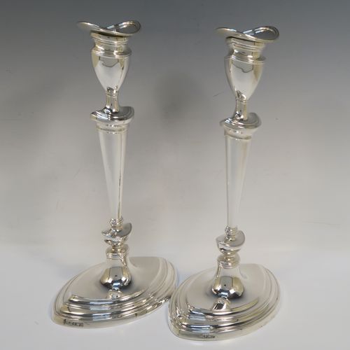 A very handsome pair of Antique Edwardian Sterling Silver candlesticks, having neoclassical plain oval boat-shaped bodies with reeded borders and tapering columns, and original removable nozzles. These elegant antique silver candlesticks were made by Thomas Bradbury of Sheffield in 1903. The dimensions of these fine hand-made antique silver candlesticks are height 30.5 cms (12 inches), and the bases are 17 cms (6.75 inches) long.   