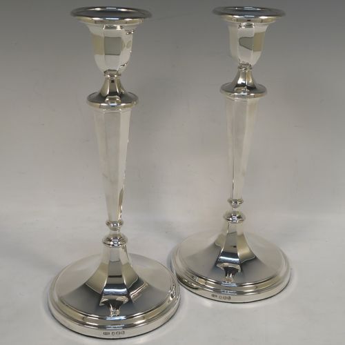 A handsome Sterling Silver pair of candlesticks, having round and octagonal panelled style bodies, with reeded borders, and removable nozzles. These beautiful silver candlesticks were made by Roberts and Belk of Sheffield in 1968. The dimensions of these fine hand-made silver table candlesticks are height 25.5 cms (10 inches), and diameter at base 12 cms (4.75 inches).  