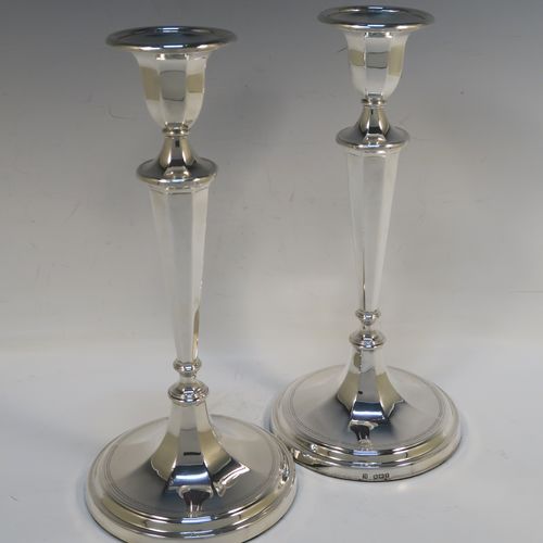 A very handsome pair of Antique Edwardian Sterling Silver candlesticks, having neoclassical round  octagonal panelled bodies with reeded borders and tapering columns, and original removable nozzles. These elegant antique silver candlesticks were made by Fordham and Faulkner of Sheffield in 1910. The dimensions of these fine hand-made antique silver candlesticks are height 25.5 cms (10 inches), and the bases are 12 cms (4.75 inches) in diameter.   