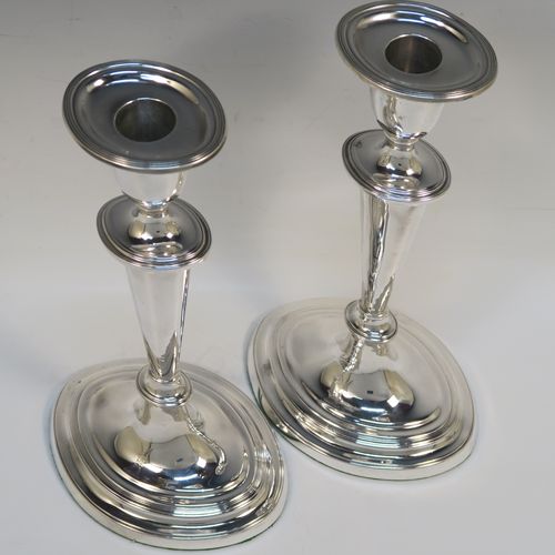 A very handsome pair of Antique Georgian Sterling Silver candlesticks, having neoclassical plain oval boat-shaped bodies with reeded borders and tapering columns, and original removable nozzles. These elegant antique silver candlesticks were made by Joseph Shemell of Sheffield in 1799. The dimensions of these fine hand-made antique silver candlesticks are height 26 cms (10.25 inches), and the bases are 14 cms (5.5 inches) long.   