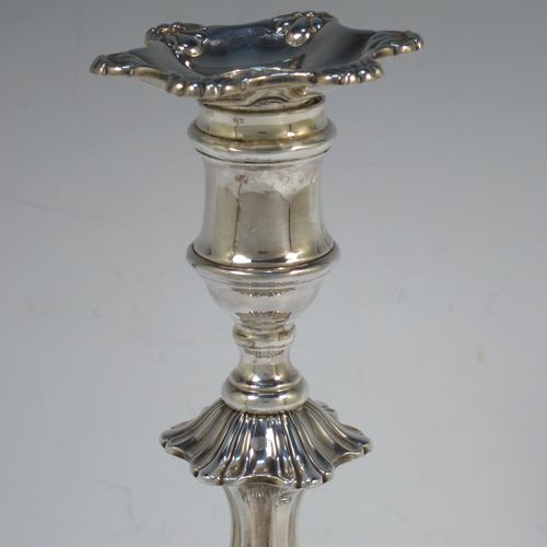 A handsome pair of Antique Georgian Sterling Silver George IV candlesticks, having round baluster bodies, with six-shell bases, and removable nozzles. Made by Kirby Westerhouse and Co., of Sheffield in 1828. The dimensions of this fine pair of hand-made antique silver candlesticks are height 23 cms (9 inches), and width at base 14 cms (5.5 inches). Please note that these candlesticks are filled, not cast.  