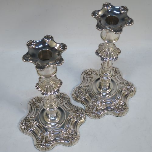 A handsome pair of Antique Georgian Sterling Silver George IV candlesticks, having round baluster bodies, with six-shell bases, and removable nozzles. Made by Kirby Westerhouse and Co., of Sheffield in 1828. The dimensions of this fine pair of hand-made antique silver candlesticks are height 23 cms (9 inches), and width at base 14 cms (5.5 inches). Please note that these candlesticks are filled, not cast.  