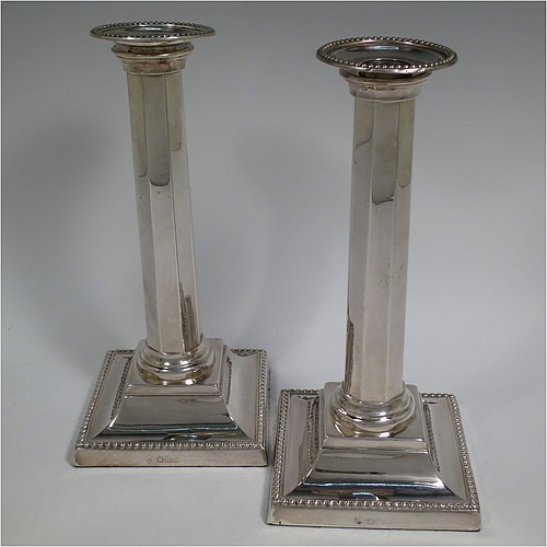 An Antique Victorian Sterling Silver pair of very pretty table candlesticks with bead-edged borders, having square bases with straight hexagonal panelled columns, with plain round capitals and removable nozzles. Made by Martin Hall and Co., of Sheffield in 1897. The dimensions of this fine hand-made pair of antique silver candlesticks are height 23 cms (9 inches), and 11 cms (4.3 inches) square at the base.    