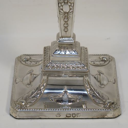 A very pretty pair of Antique Victorian Sterling Silver Neoclassical style candlesticks, having bead-edged borders, with hand-chased rams heads, swags, ribbons, and tureens, with removable nozzles, and square bases. These beautiful antique silver candlesticks were made by William Hutton and Sons of London in 1895. The dimensions of this fine hand-made pair of antique silver candlesticks are height 20 cms (8 inches), and the bases are 9 cms (3.5 inches) square.   