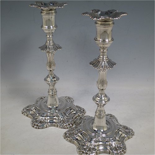 An Antique Georgian cast Sterling Silver pair of George II candlesticks, having baluster bodies, with six-shell bases, and removable nozzles. Made by John Cafe of London in 1754. The dimensions of this fine pair of hand-made antique silver candlesticks are height 22 cms (8.75 inches), width at base 13 cms (5.25 inches), and they weigh a total of 1,106g (35.7 troy ounces). Please note that these items are part-crested.    