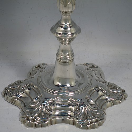 An Antique Georgian cast Sterling Silver pair of George II candlesticks, having baluster bodies, with six-shell bases, and removable nozzles. Made by John Cafe of London in 1754. The dimensions of this fine pair of hand-made antique silver candlesticks are height 22 cms (8.75 inches), width at base 13 cms (5.25 inches), and they weigh a total of 1,106g (35.7 troy ounces). Please note that these items are part-crested.    