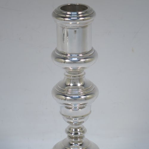 A very elegant set of four cast Sterling Silver candlesticks in a George I style, having plain round baluster bodies, and sitting on plain octagonal bases. Made by Goldsmiths and Silversmiths of Sheffield in 1931. The dimensions of this fine set of hand-made silver table candlesticks are height 19 cms (7.5 inches), the bases are 12.5 cms (5 inches) square, and the total weight is 1,602g (52 troy ounces)  